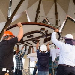 Рабочие поднимают символ Величайшего Имени, готовясь установить его на вершине купола Храма.